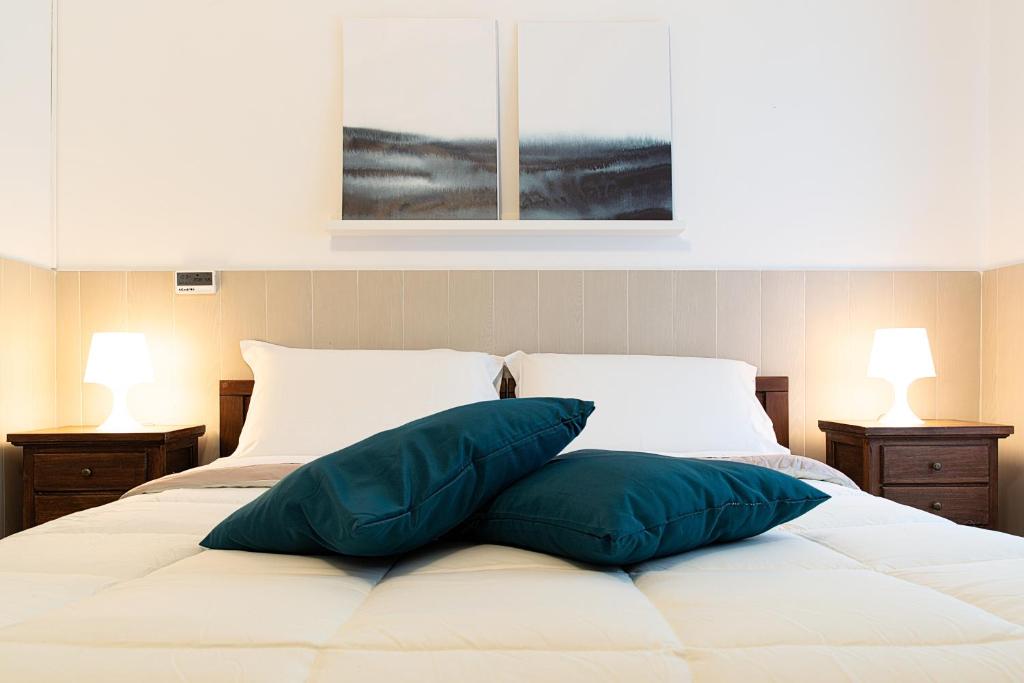un letto bianco con due cuscini sopra di Fox House BnB a L'Aquila