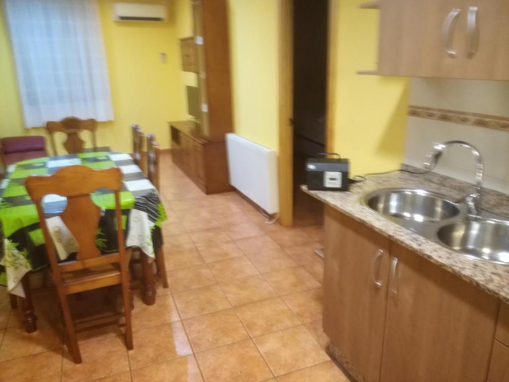 a kitchen with a sink and a table with a tableablish at Apartaments la Fabrica in Horta de San Joan