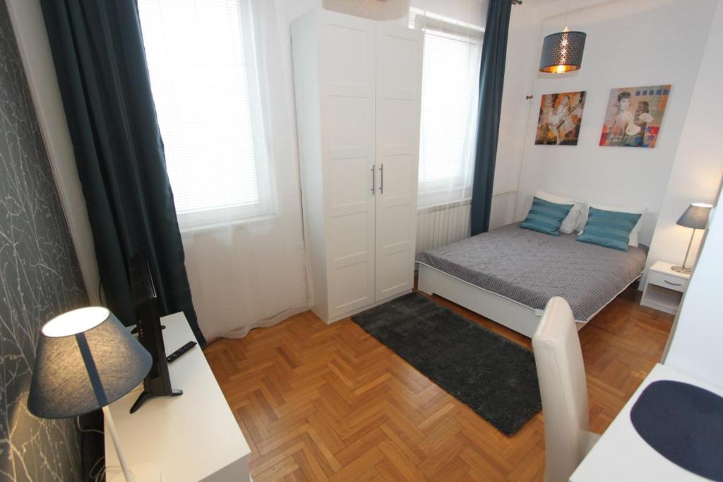 una piccola camera con letto e finestra di Apartment Bg Arena a Belgrado