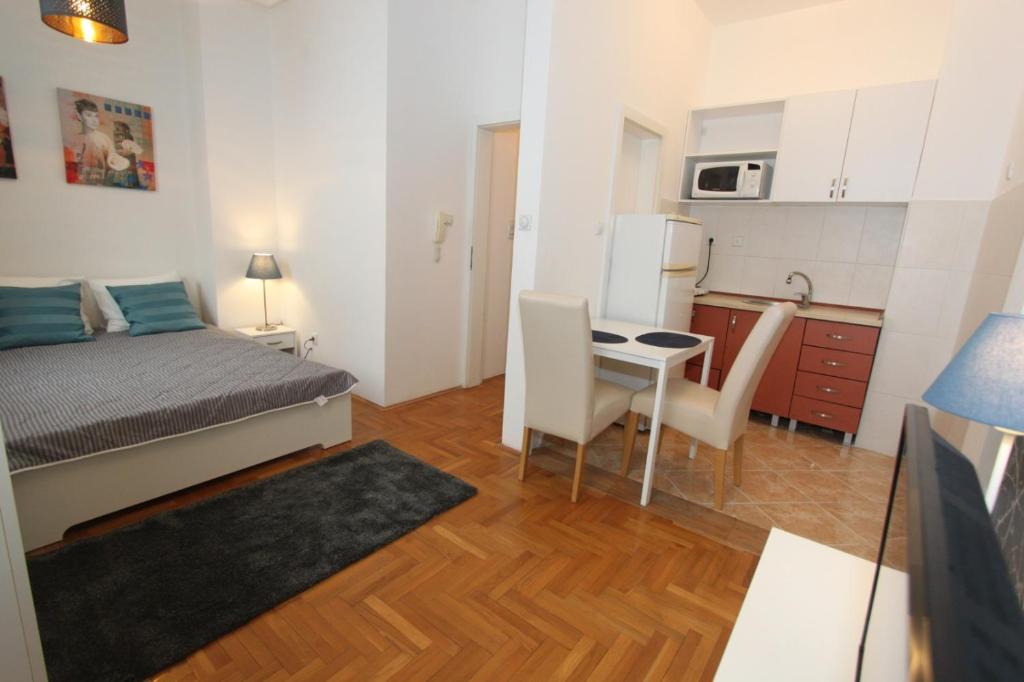 1 dormitorio con cama, mesa y cocina en Apartment Bg Arena, en Belgrado