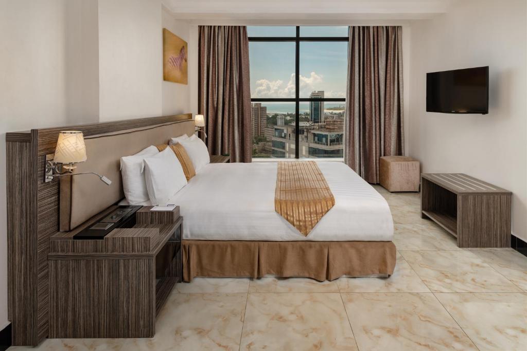 Postel nebo postele na pokoji v ubytování Golden Tulip Dar Es Salaam City Center Hotel