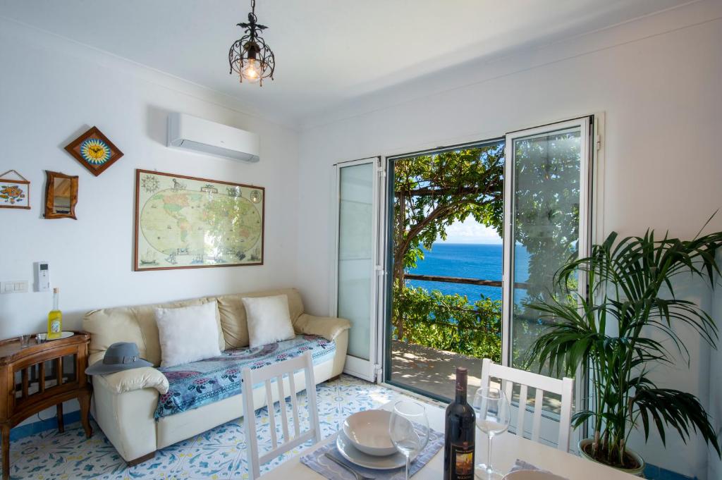 a living room with a couch and a view of the ocean at Sea Side Solandra in Praiano