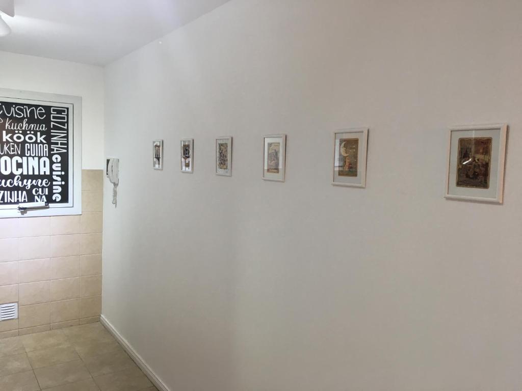 a white wall with four pictures on it at Departamento Laura con Cochera in Villa María