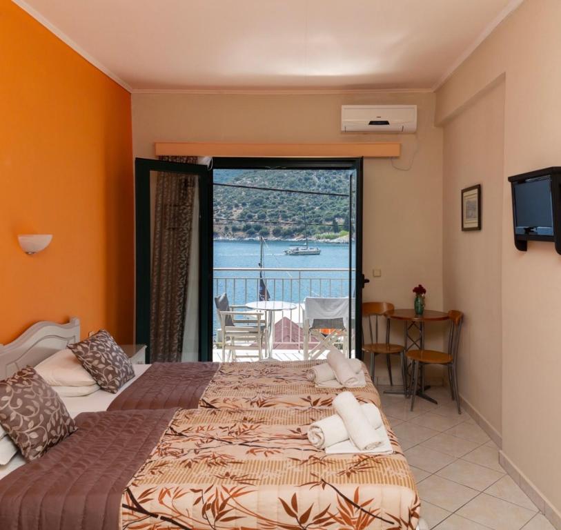 a bedroom with two beds and a view of the ocean at Poseidon Apartments in Ayia Evfimia