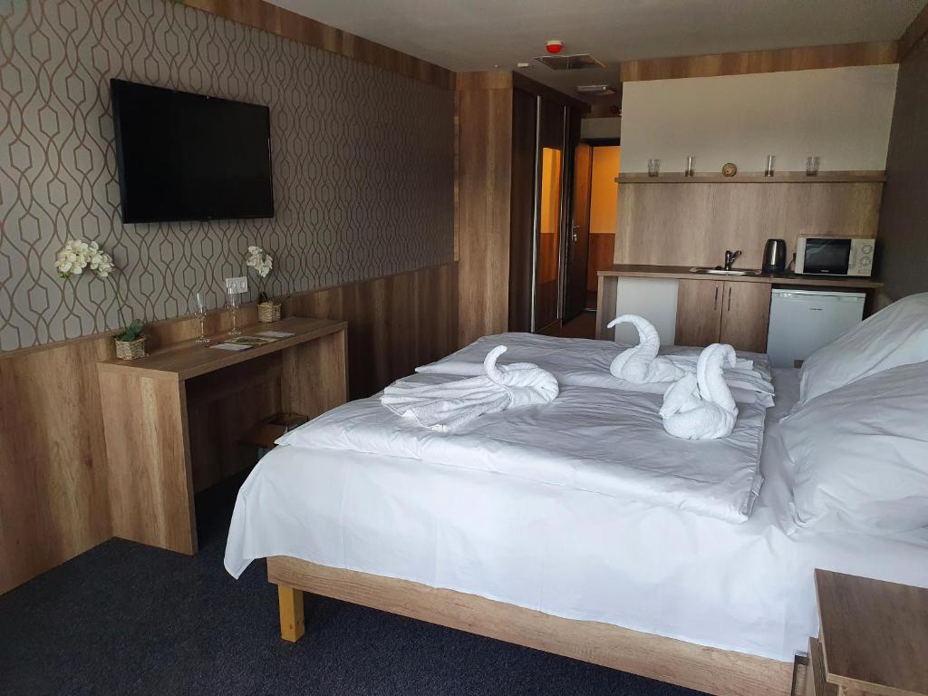ein Hotelzimmer mit Schwänen auf einem Bett in der Unterkunft miniHotel Pápa in Pápa