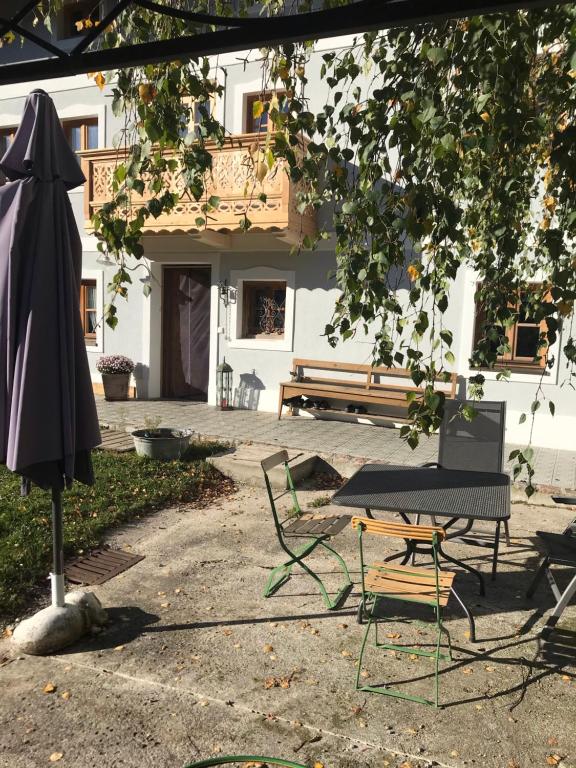 eine Terrasse mit einem Tisch, Stühlen und einem Sonnenschirm in der Unterkunft Pferdehof Dietzsch, Tittmoning in Tittmoning