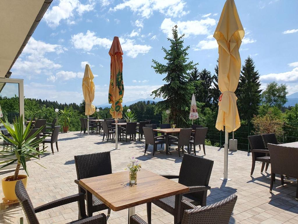 a patio with tables and chairs and umbrellas at Gasthof Thomann in Velden am Wörthersee