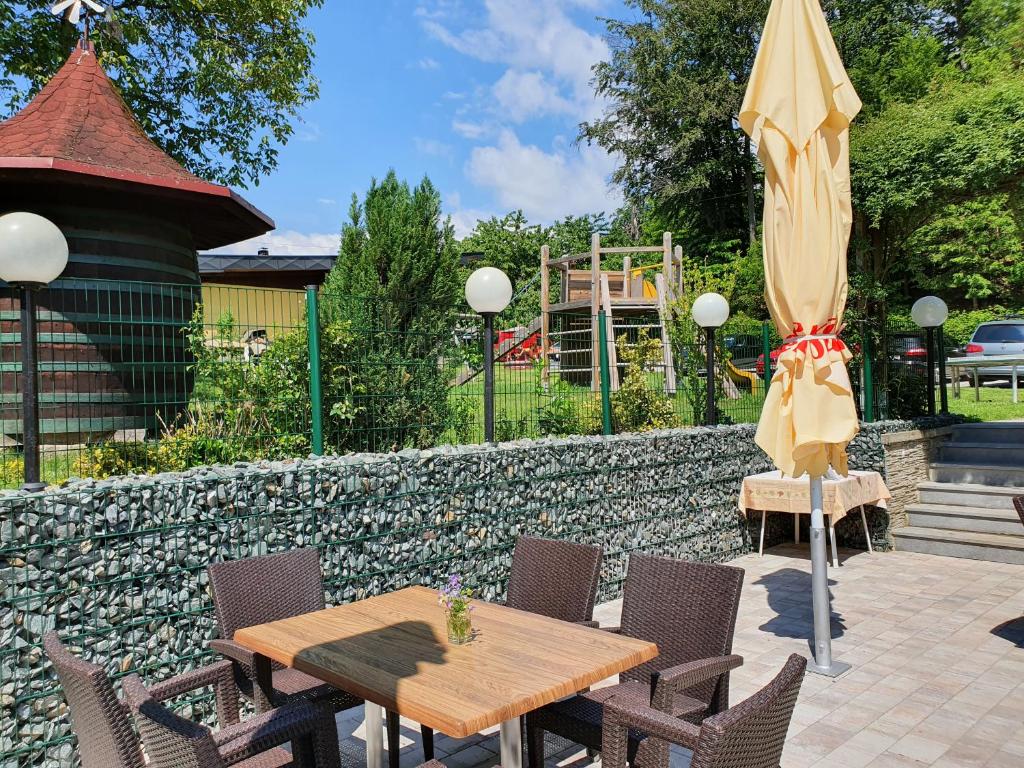 a patio with a table and chairs and an umbrella at Gasthof Thomann in Velden am Wörthersee