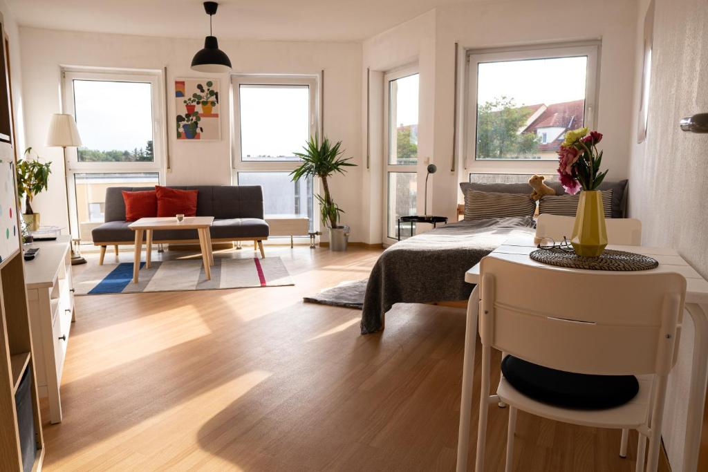 salon z kanapą i stołem w obiekcie FULL HOUSE Studios - KornhausPremium Apartment - Balkon, WiFi w mieście Dessau