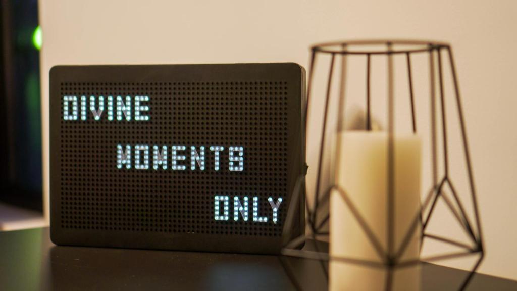 a clock sitting on top of a table with a candle at Divine moments apartment@Calbucet ski slope in Predeal