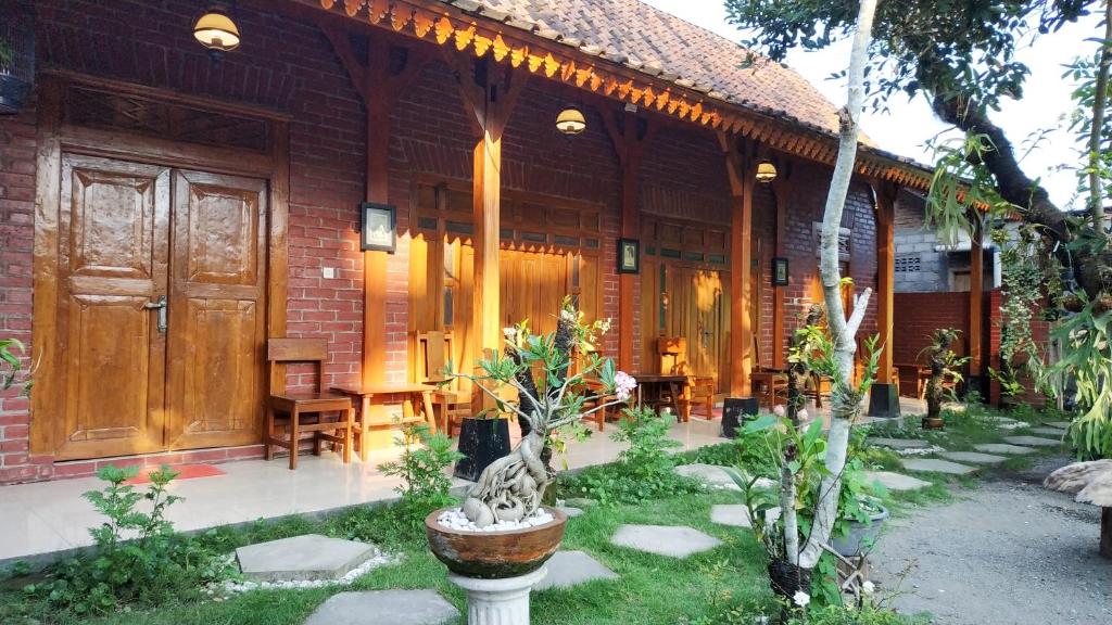 a house with a wooden door and a patio at Dapur ethnic guesthouse in Bantul