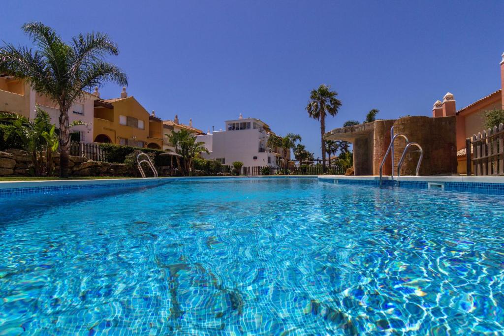 a large swimming pool with blue water at Zahara Sol Villas y Apartamentos by QHotels in Zahara de los Atunes