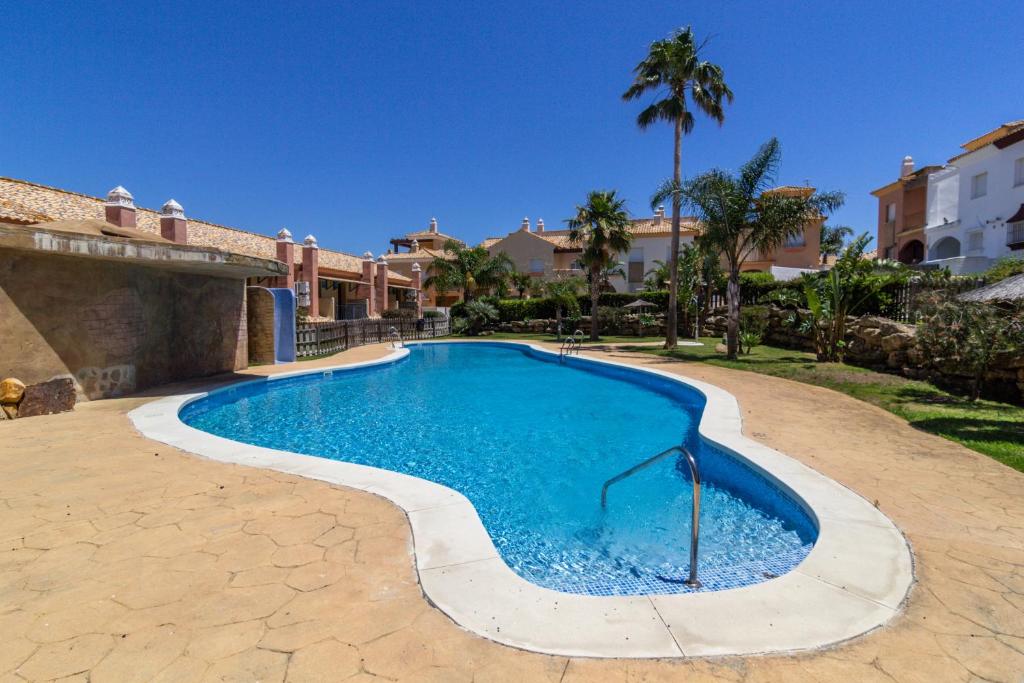 a swimming pool in a yard with a house at Zahara Sol Villas y Apartamentos by QHotels in Zahara de los Atunes