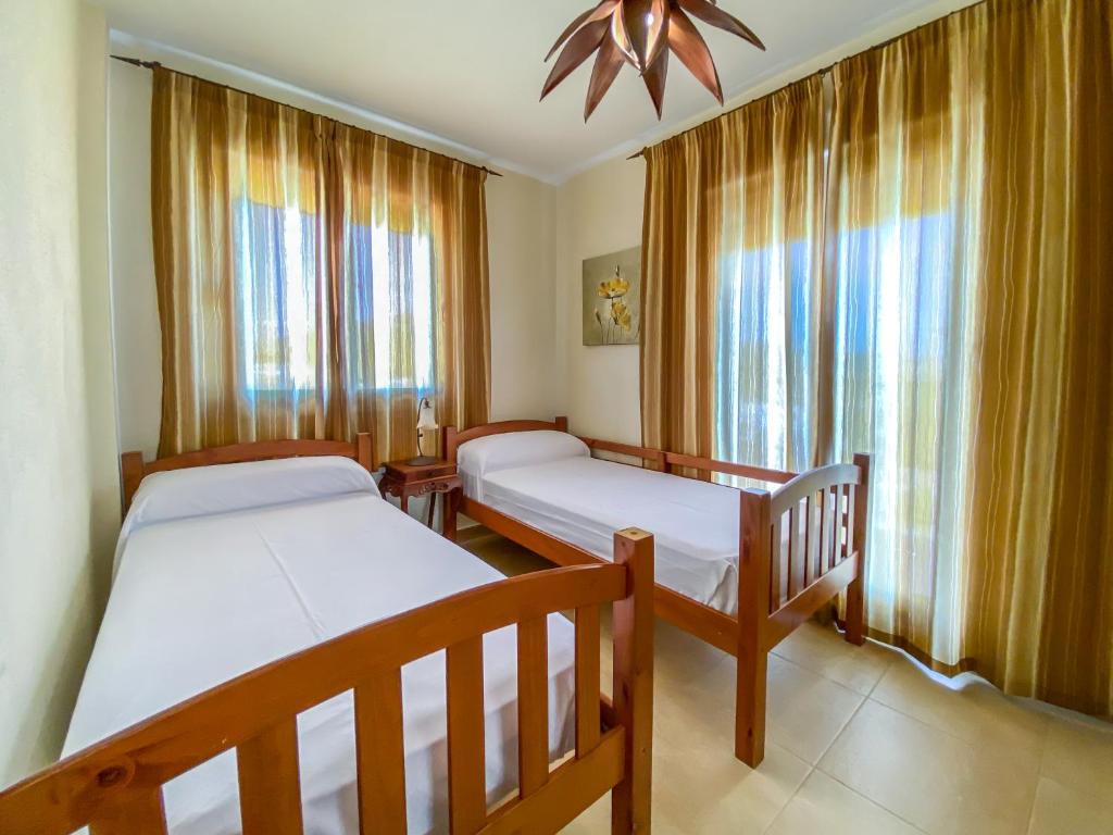 a bedroom with two beds and a ceiling fan at Zahara Sol Villas y Apartamentos by QHotels in Zahara de los Atunes
