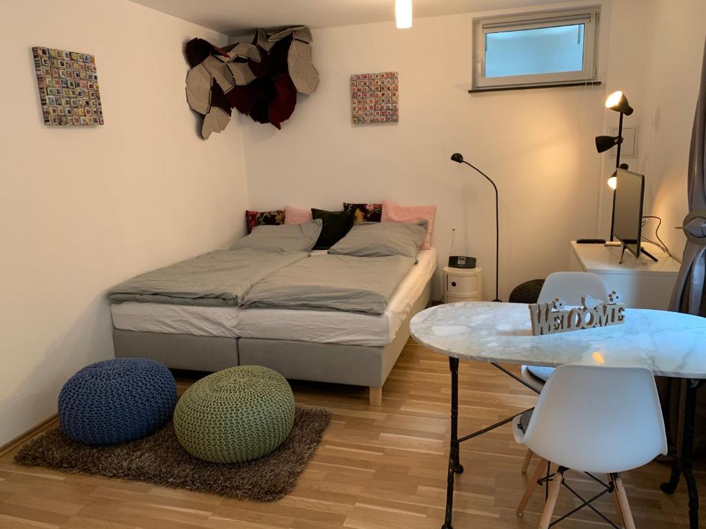 sypialnia z łóżkiem, stołem i krzesłami w obiekcie Helle Souterrainwohnung mit Komfort w Monachium
