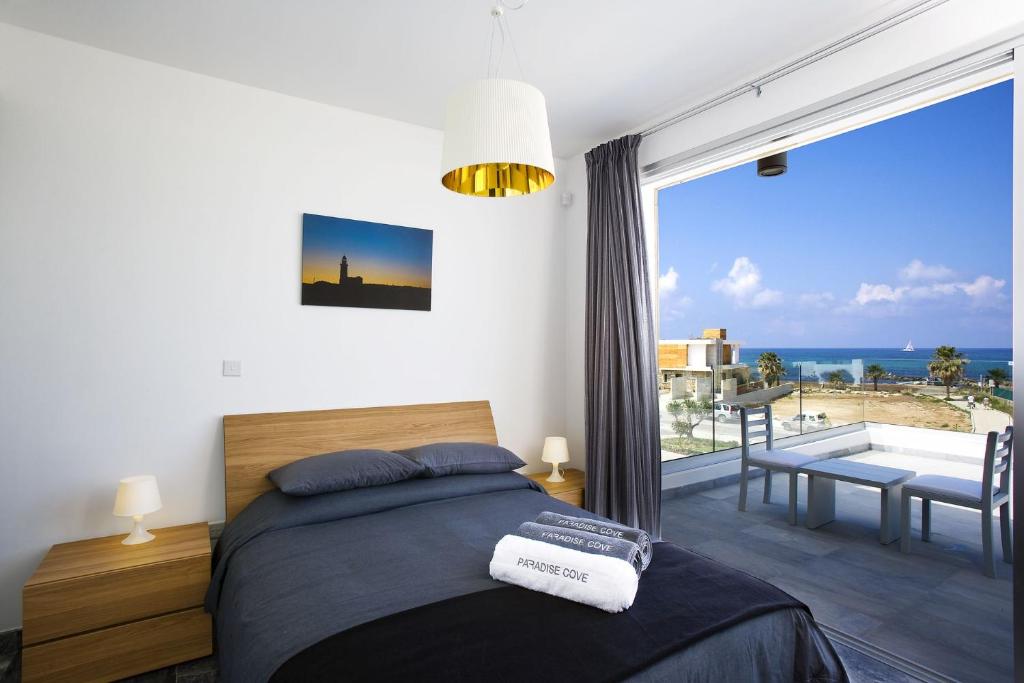 a bedroom with a bed and a view of the ocean at Luxury Cyprus Villa Turquoise Villa Private Pool Sea View 1 BDR Paphos in Paphos