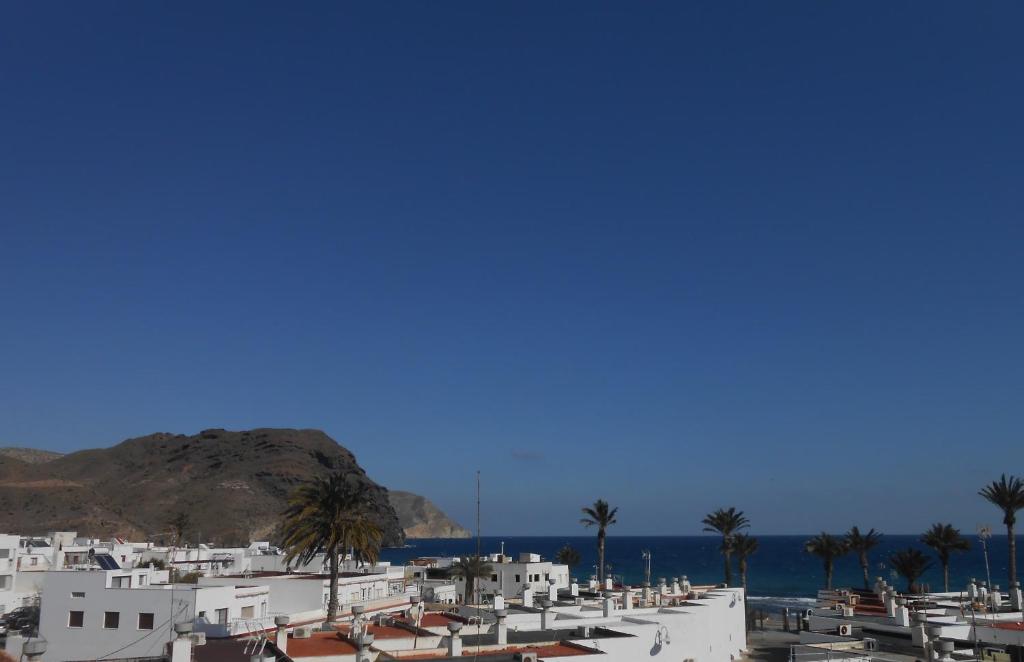 eine Reihe von weißen Gebäuden mit Palmen und dem Meer in der Unterkunft El Sol de Las Negras con vistas al mar in Las Negras