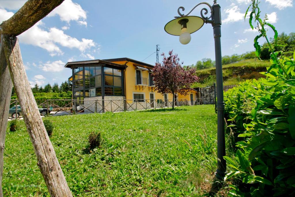 uma casa num campo com uma luz de rua em Agriturismo Maneggio Vallecupa em Pescasseroli