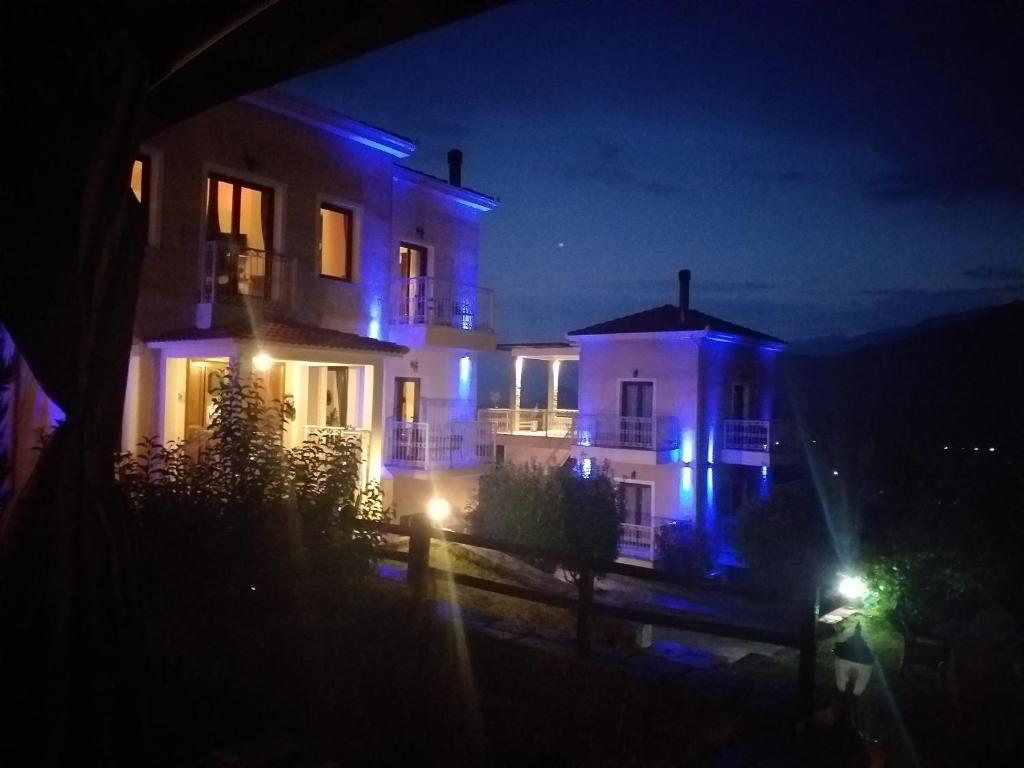 una casa iluminada por la noche con luces azules en Epavlis Meteora Suites Hotel, en Kalambaka