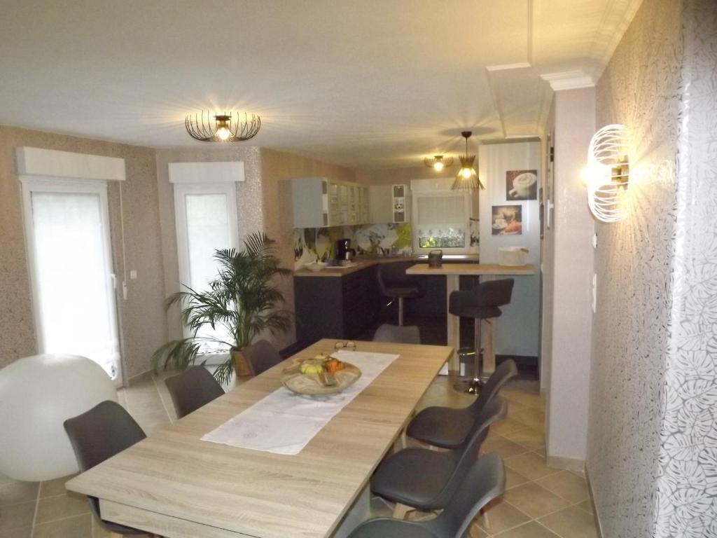 eine Küche und ein Esszimmer mit einem Holztisch und Stühlen in der Unterkunft Großzügige Ferienwohnung am Waldesrand im Seenland in Laubusch