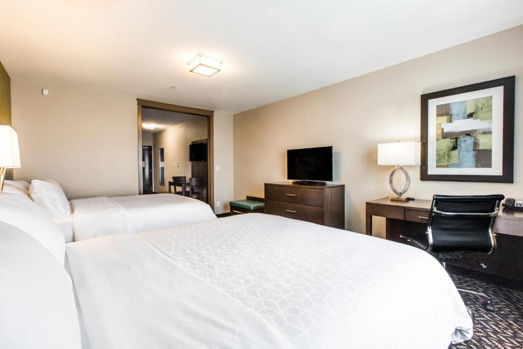 a hotel room with two beds and a desk and a television at Holiday Inn Express & Suites Spruce Grove - Stony Plain by IHG in Spruce Grove