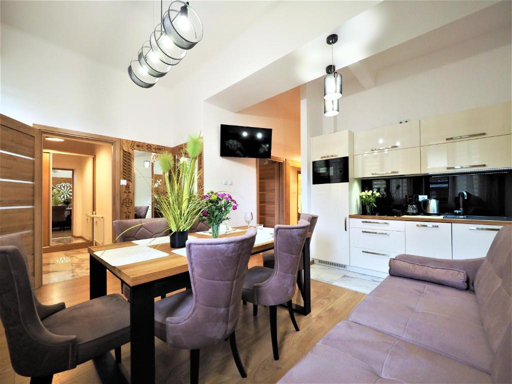a kitchen and dining room with a table and chairs at VIP Apartamenty TYTUS in Zakopane