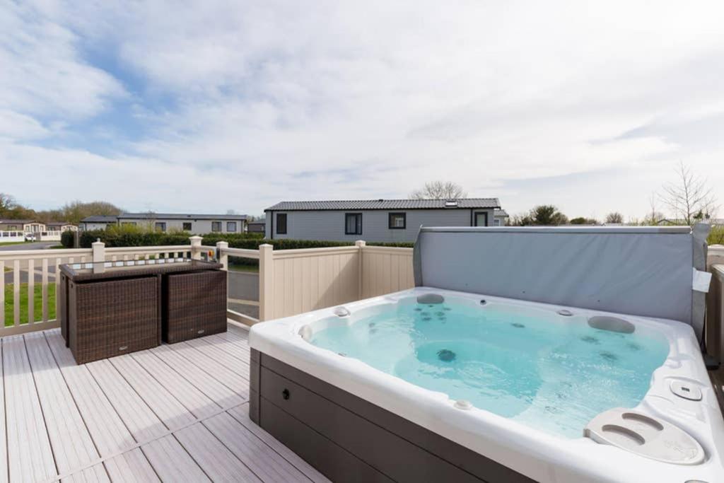 a hot tub on the deck of a house at Thumper Lodge - Luxury lodge with Hot Tub in South Cerney