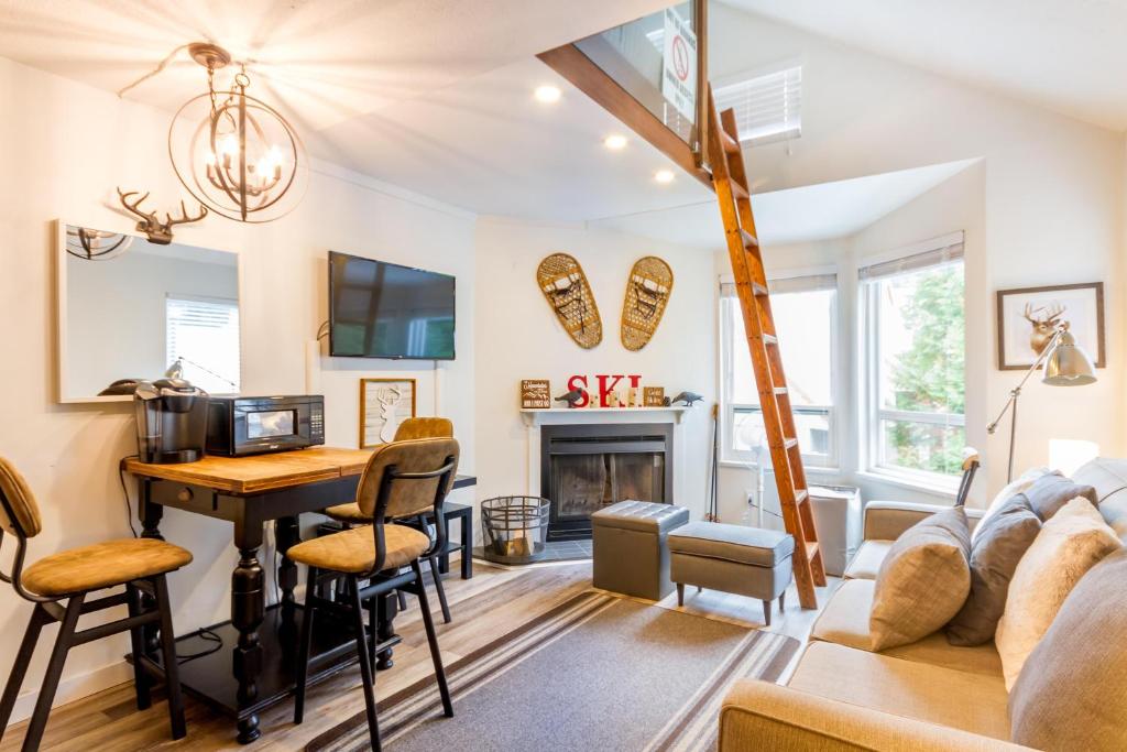 a living room with a table and a fireplace at Cute and Cozy, walk to Gondola Ski in Out in Whistler