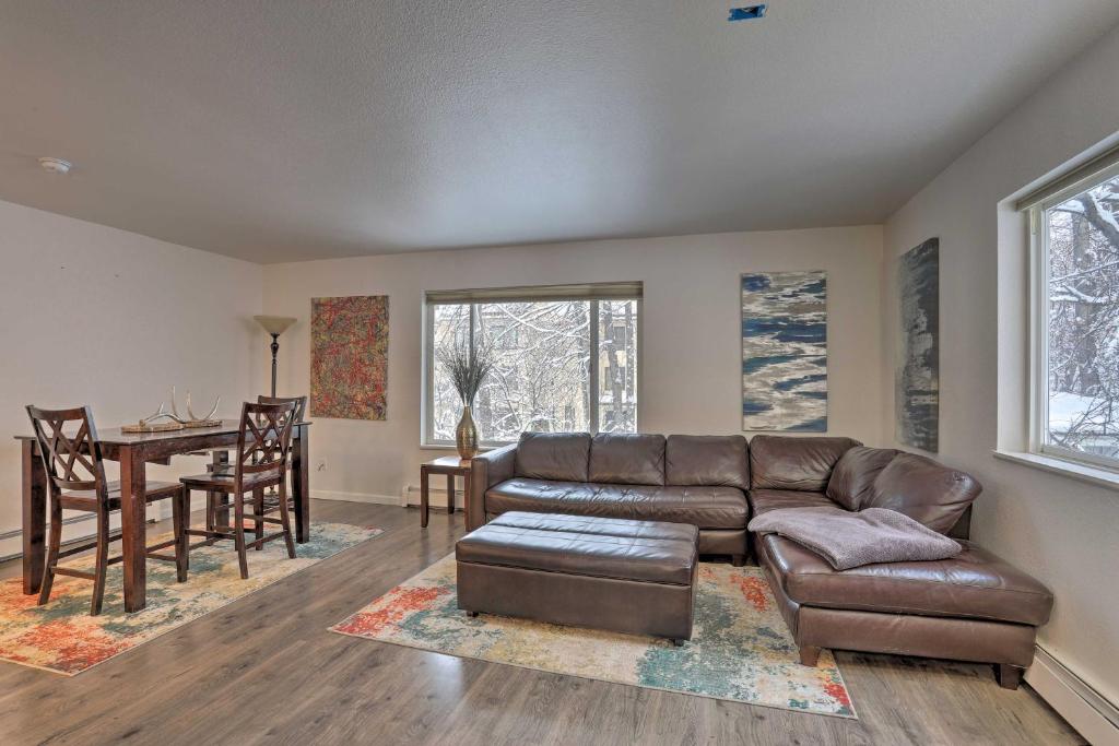 a living room with a leather couch and a table at Waterfront Apt, Walk to Town and Coastal Trail! in Anchorage