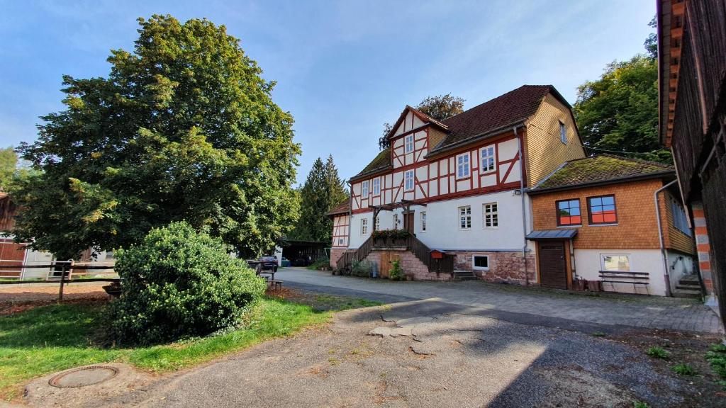 a large white and red house on a street at Ferienwohnung auf idyllischen Gestüt auf historischen Gutshof in Hessen in Bad Hersfeld