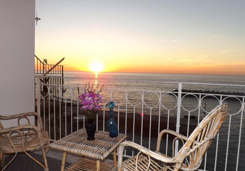 een balkon met 2 stoelen en een tafel met uitzicht op de oceaan bij Casa Vacanze Porto delle Gatte in Santa Maria di Castellabate