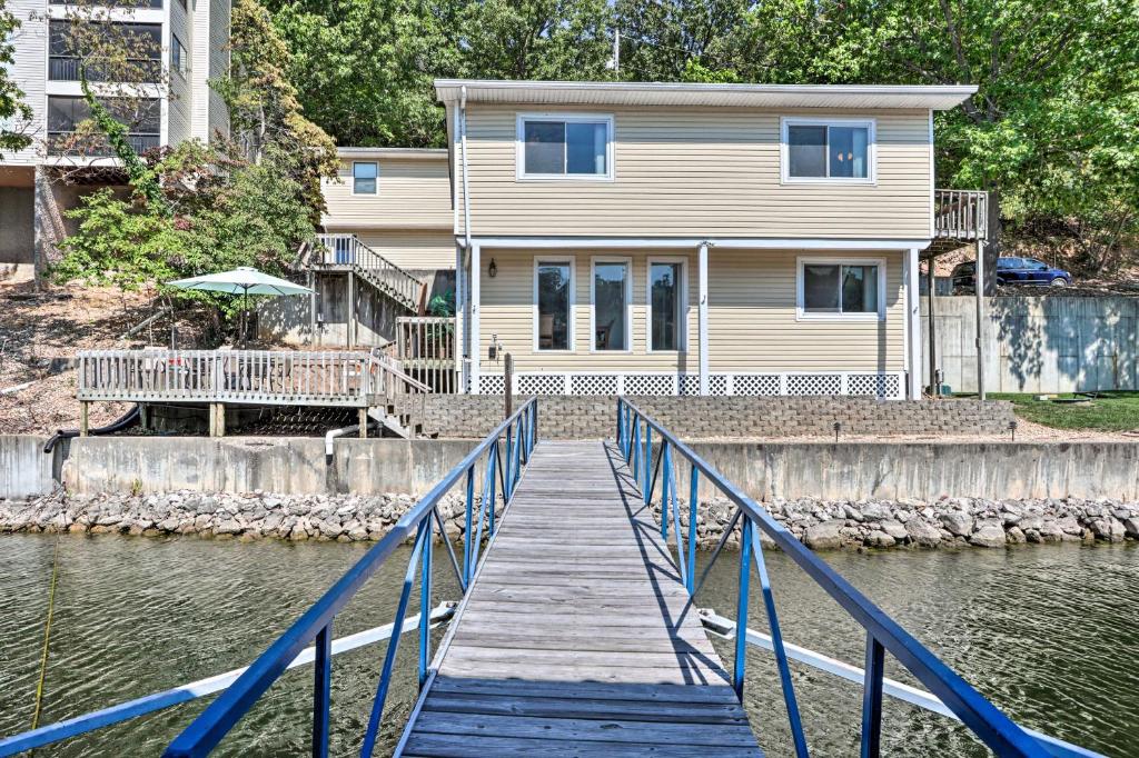 une maison sur l'eau avec un quai en bois dans l'établissement On-the-Water Retreat with Dock Pet Friendly!, à Lac des Ozarks