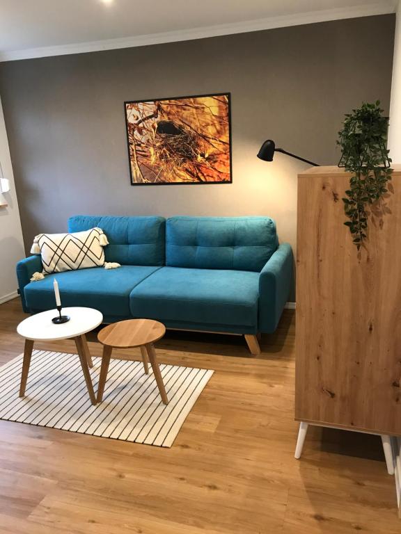 a living room with a blue couch and a table at Ferienwohnung Siedlungsnest in Anklam