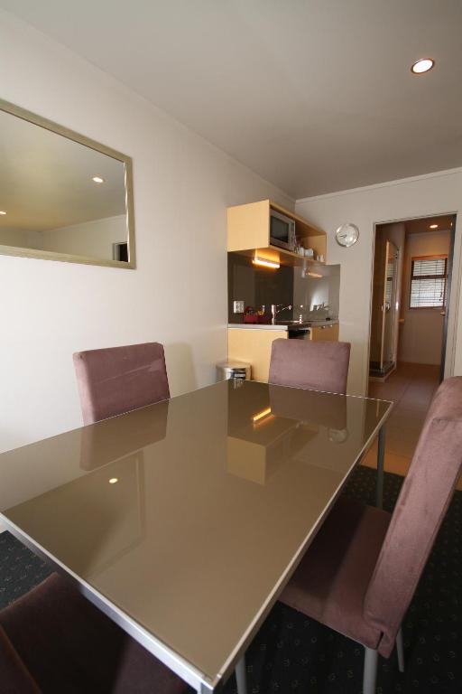 a dining room table with two chairs and a mirror at Bentleys Motor Inn in Palmerston North