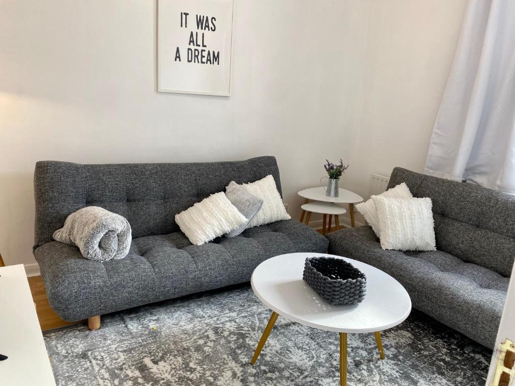 un soggiorno con divano grigio e 2 tavoli di Beautiful 2 bedroom flat in Camden a Londra