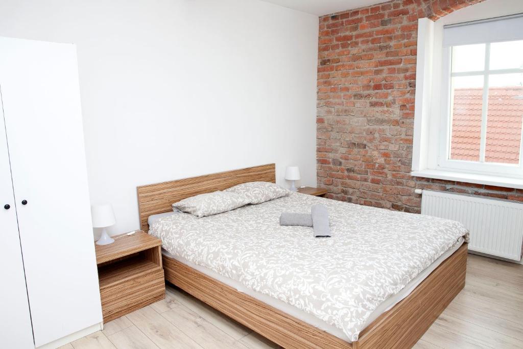 a bedroom with a bed and a brick wall at Old Town Mystery- in Poznań