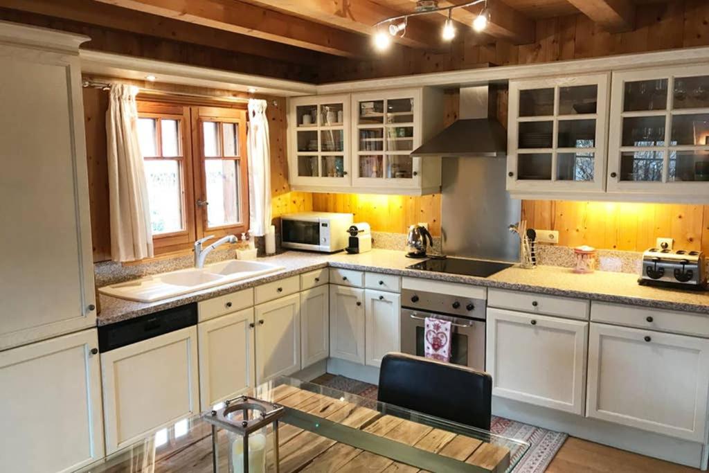 a kitchen with white cabinets and a sink at Family Chalet Central Chamonix Mont Blanc Views in Chamonix-Mont-Blanc