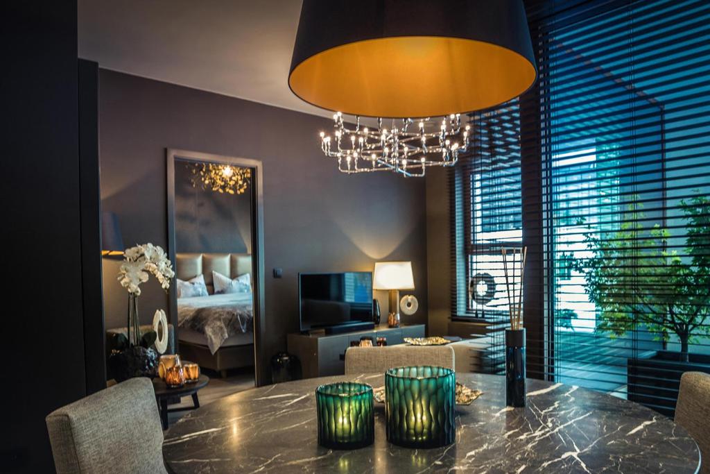 een woonkamer met een eettafel met een kroonluchter bij The 0507 A Luxury Flat in Antwerp in Antwerpen