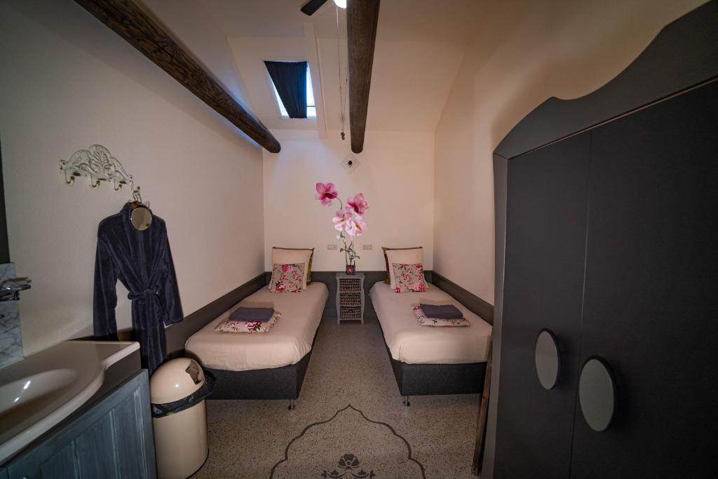 uma casa de banho com 2 camas e um lavatório num quarto em Veldzicht em Winkel