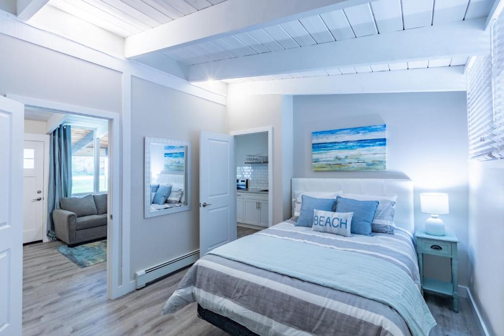 a white bedroom with a bed and a chair at Boutique Suite #4 in Blue Mountains