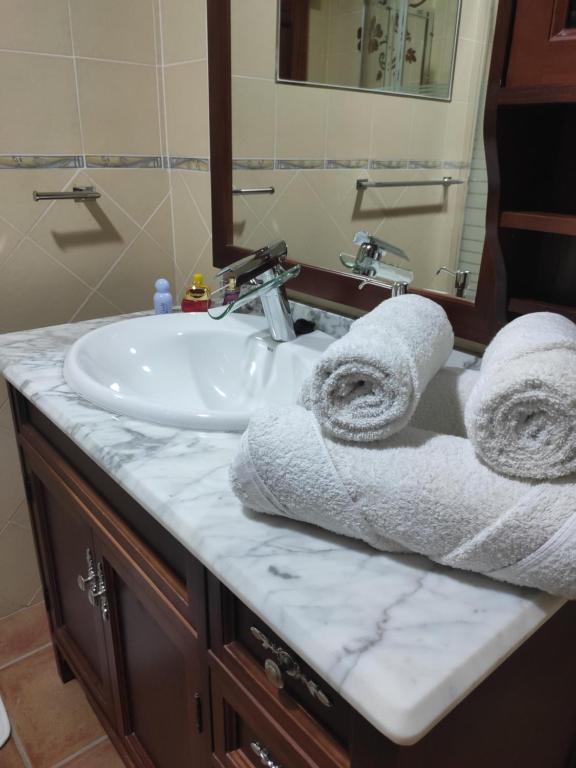 La salle de bains est pourvue d'un lavabo et de serviettes sur un comptoir. dans l'établissement Vivienda vacacional, à Puerto del Rosario