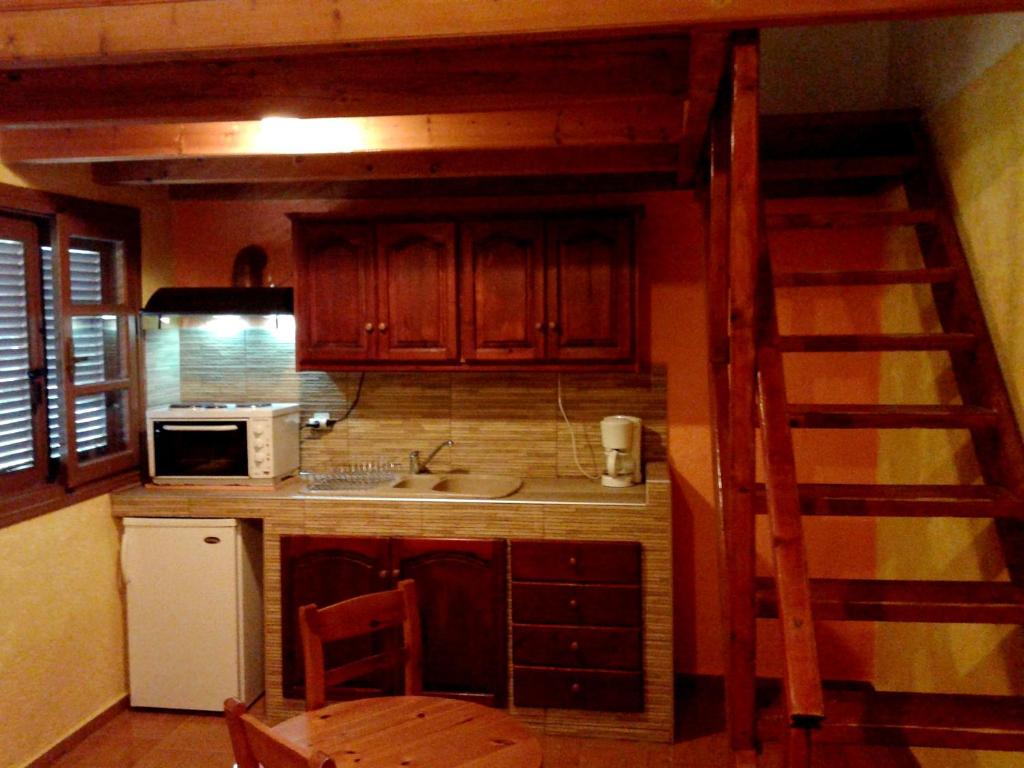 a kitchen with a staircase leading up to a loft at Sunrise Apartments in Palekastron
