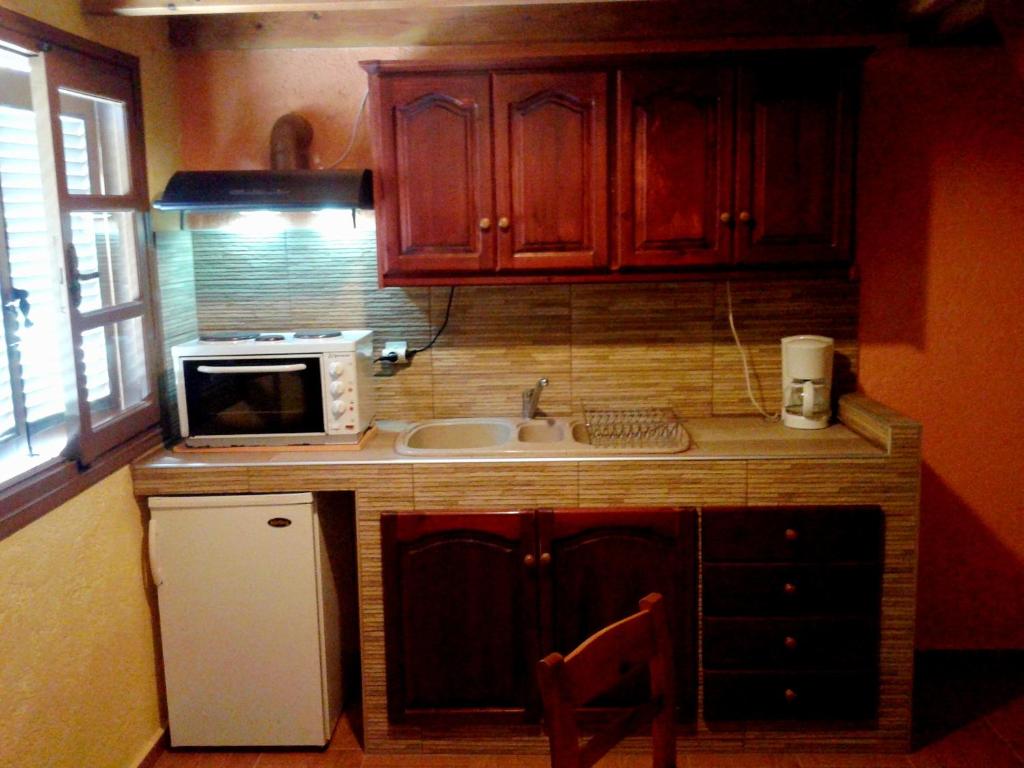 a small kitchen with a sink and a microwave at Sunrise Apartments in Palekastron
