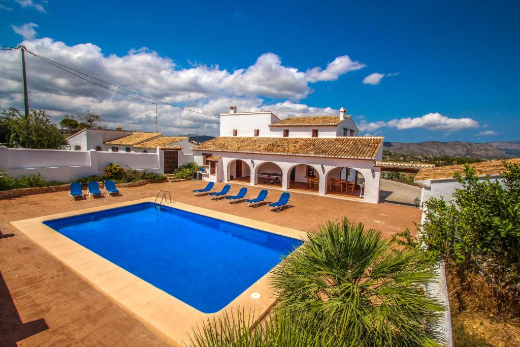 une villa avec une piscine en face d'une maison dans l'établissement Finca Pere - panoramic hillside holiday house in Benissa, à Teulada