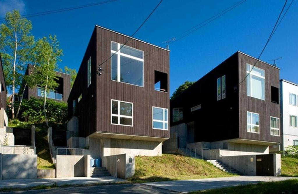 a large brick building with windows on a street at Forest Estate in Niseko