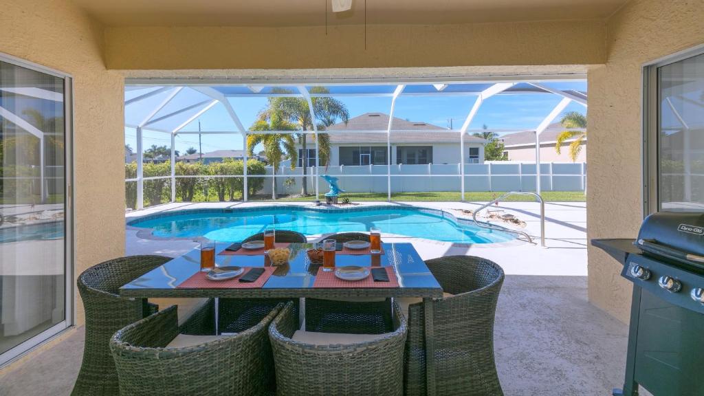 une terrasse avec une table et des chaises ainsi qu'une piscine dans l'établissement !NEW! Villa Surfside, à Cape Coral