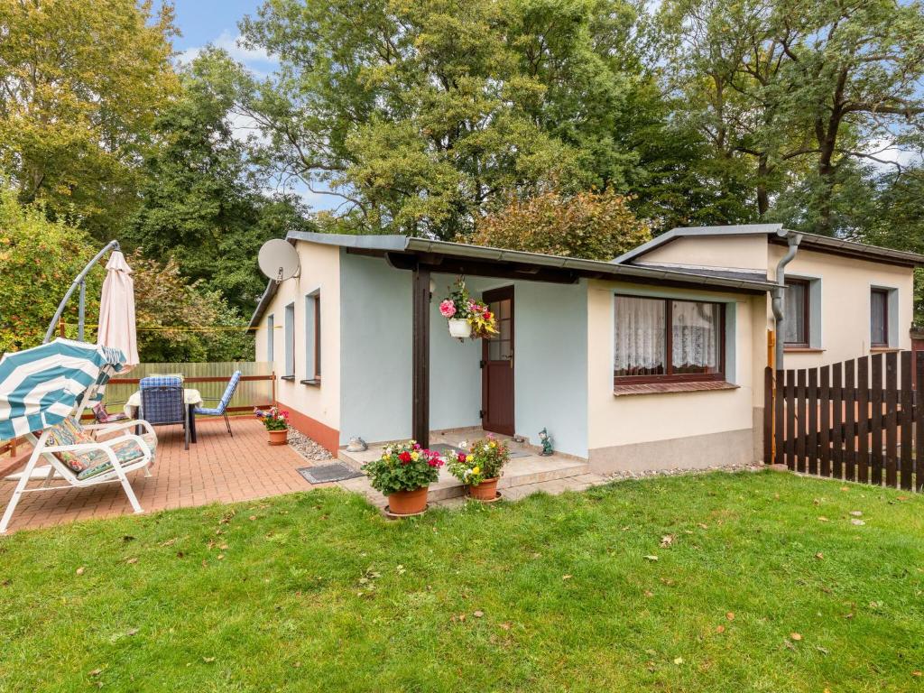 uma pequena casa com um pátio e um quintal em Beautiful Holiday House In Biendorf with Garden em Körchow