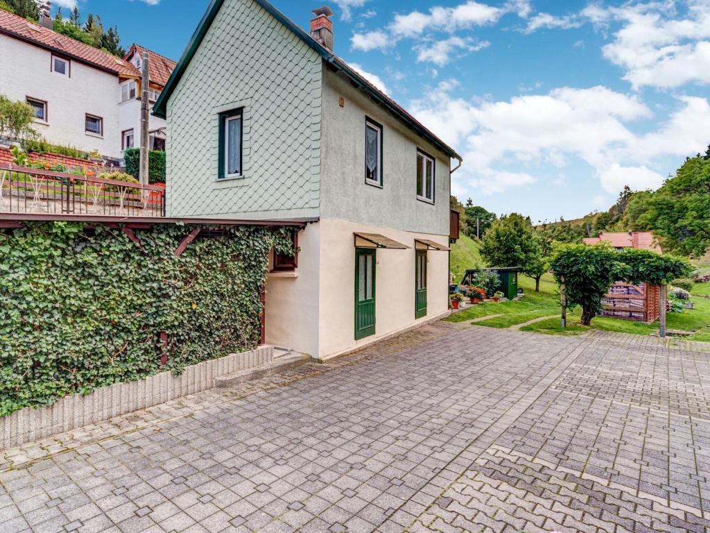 a house with a brick driveway next to a building at Holiday home with garden in Langenbach