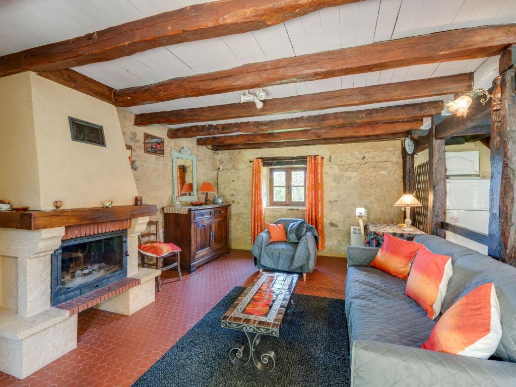 a living room with a couch and a fireplace at Cosy holiday home with garden in Villefranche-du-Périgord