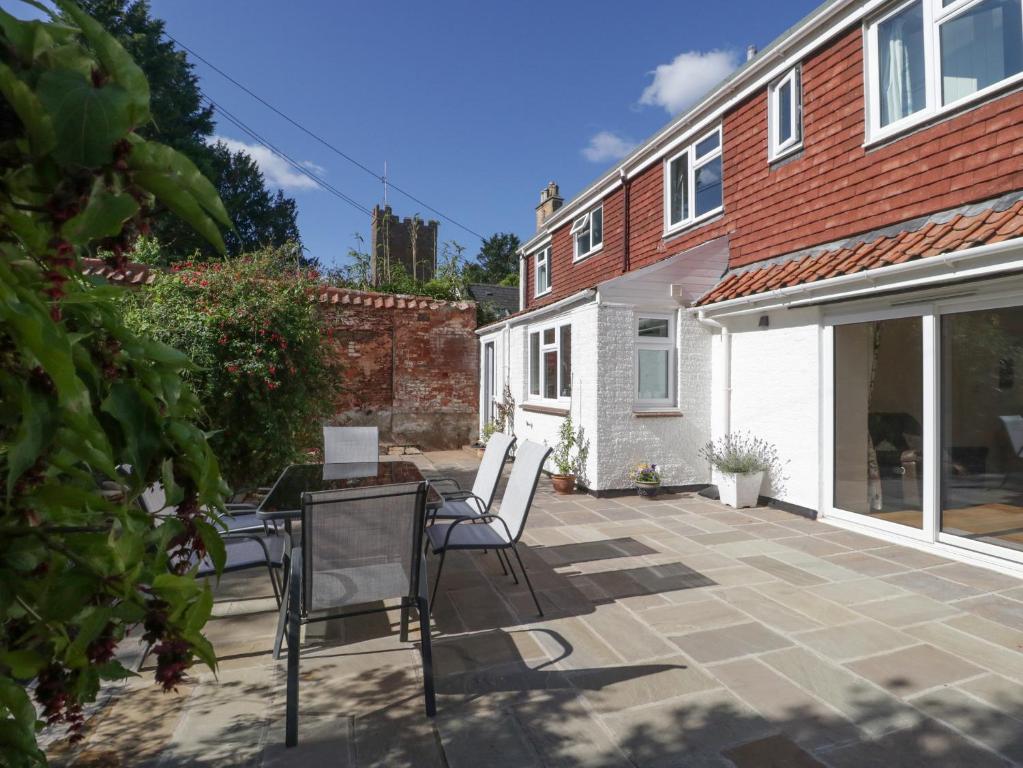 a patio with chairs and a table and a house at The Gardens in Bridgwater